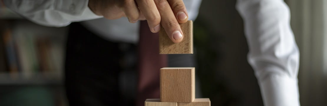 Businessman stacking building blocks representing business concept growth success process.